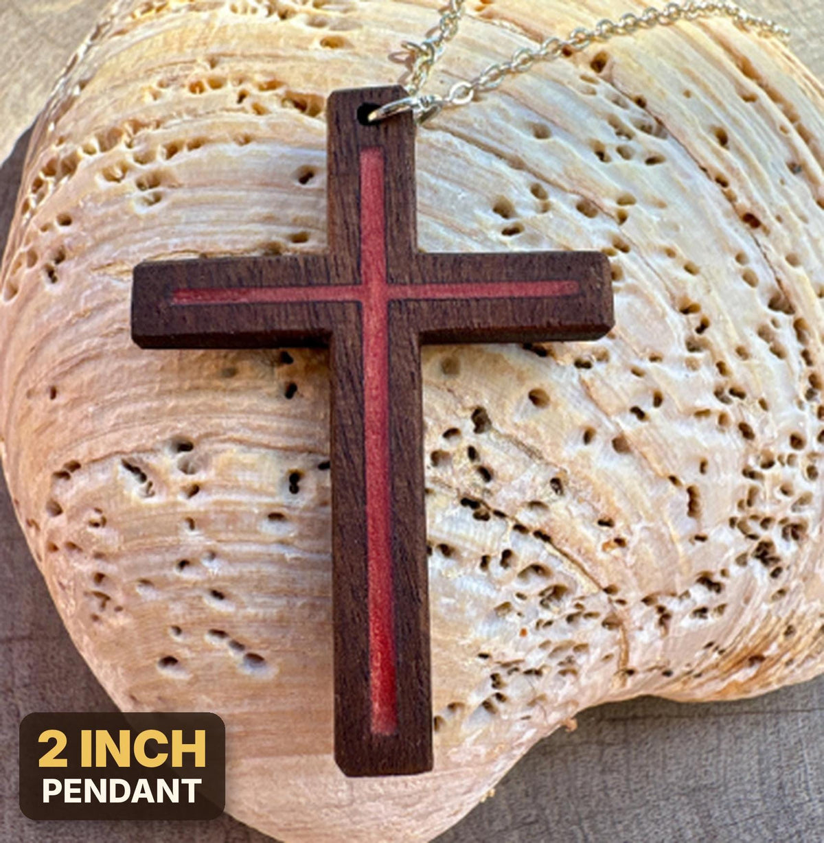 Red resin-inlay walnut cross necklace with silver-colored chain on a pale seashell, labeled 2-inch pendant